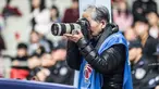 Fotografer Hong Nanli mengambil gambar saat pertandingan bola basket di Shanghai (16/1). Hong Nanli 79 tahun memulai karirnya sebagai fotografer sejak 1979, ia juga merupakan fotografer olah raga tertua di China. (AFP Photo/China Out)