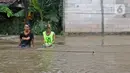 Warga duduk-duduk saat banjir di RW 06 kawasan Mekarsari, Depok, Jawa Barat, Sabtu (20/2/2021). Banjir yang disebabkan meluapnya aliran Kali Cipinang Timur ini terjadi akibat intensitas hujan tinggi di wilayah tersebut (Liputan6.com/Herman Zakharia)