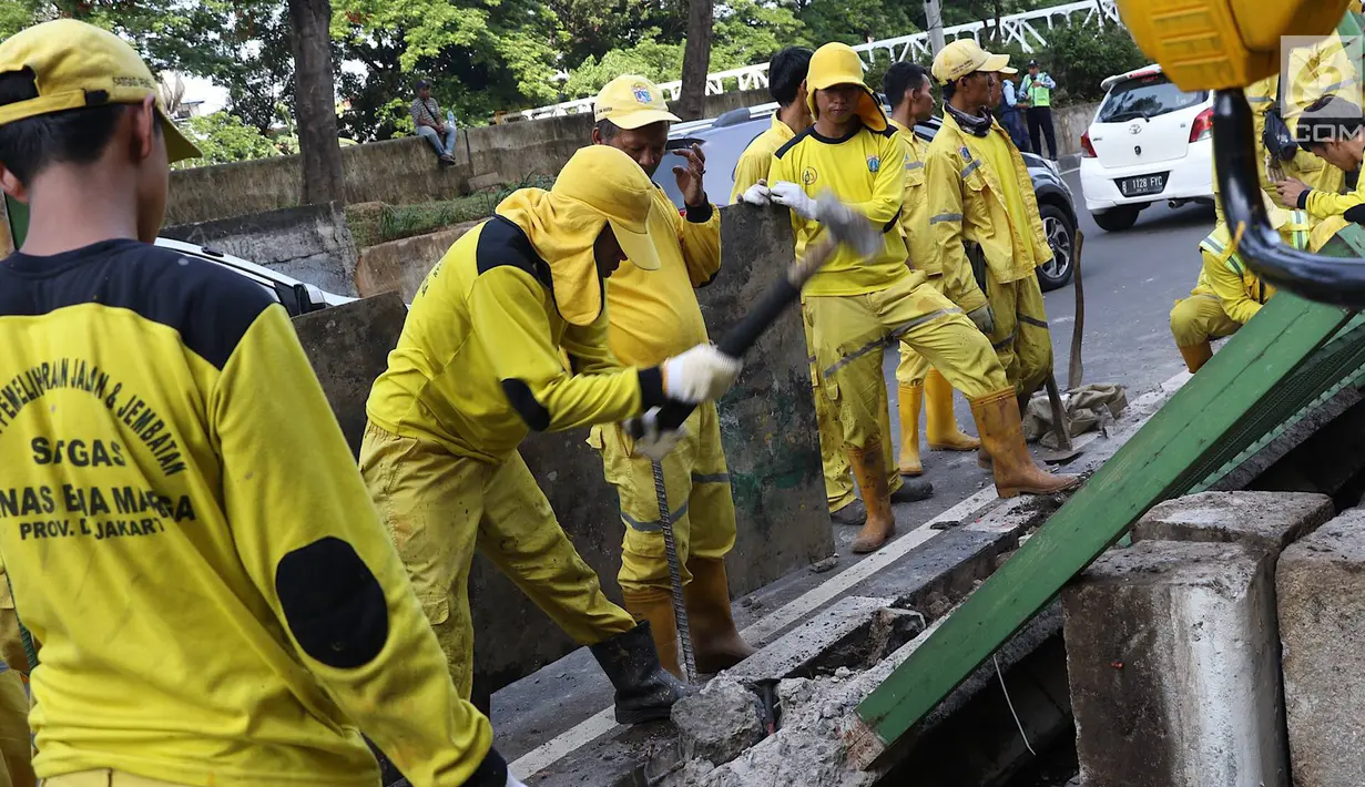 Petugas Dinas Bina Marga membongkar pagar dan sepatator di Jalan Galunggung, Jakarta, Kamis (10/1). Pembongkaran dilakukan guna menghilangkan batas antar jalur sehingga diharapkan dapat mengurai simpul kemacetan. (Liputan6.com/Immanuel Antonius)