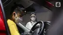 SPG berdiri dekat mobil yang dipamerkan di Indonesia International Motor Show (IIMS) Hybrid 2021, JiExpo Kemayoran, Jakarta, Kamis (16/4/2021). Acara digelar secara daring dan kunjungan langsung dengan pembatasan kapasitas dan penerapan protokol kesehatan COVID-19. (Liputan6.com/JohanTallo)