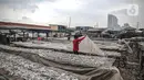 Pekerja menjemur ikan saat proses pengasinan di kawasan Muara Angke, Jakarta, Senin (26/12/2022). Nelayan mengaku produksi ikan asin di muara angke mengalami penurunan, disebabkan terhambatnya proses pengeringan di musim hujan. (Liputan6.com/Faizal Fanani)