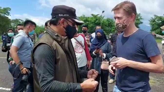 Wali Kota Bogor Bima Arya menemui rombongan WNA yang terjaring razia ganjil genap, Jumat (12/2/2021). Pemkot Bogor menerapkan kebijakan ganjil genap untuk menekan laju penularan Covid-19 di wilayahnya. (Liputan6.com/Achmad Sudarno)