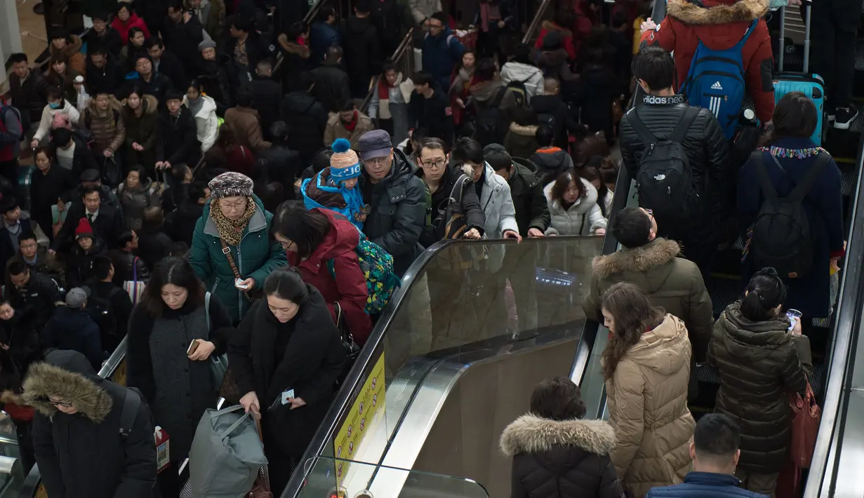 Kepadatan calon penumpang di stasiun kereta api yang akan pulang ke kampung halaman mereka, Beijing, China (23/1). Menjelang tahun baru Imlek, warga di China juga melakukan mudik untuk merayakan bersama keluarga. (AFP/Nicolas Asfouri)