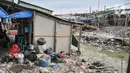 Warga saat mencuci piring di kampung nelayan Kalibaru, Cilincing, Jakarta Utara, Selasa (22/3/2022). Sementara untuk kebutuhan MCK, warga tetap menggunakan air sumur yang diendapkan terlebih dahulu. (merdeka.com/Iqbal S Nugroho)