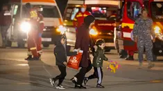 Seorang perempuan dan dua anak, dievakuasi dari Gaza, tersenyum saat berjalan di landasan setelah tiba dari Mesir di pangkalan angkatan udara Baza 90 di Otopeni, Rumania, Rabu, 8 November 2023. (AP Photo/Andreea Alexandru)