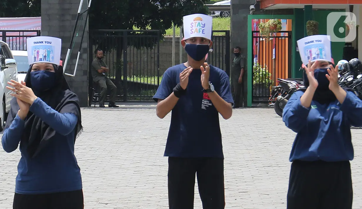 Mahasiswi Politeknik Kesehatan Jakarta III bertepuk tangan selama 56 detik pada Hari Kesehatan Nasional ke-56 di Jatiwarna, Bekasi, Jawa Barat, Kamis (12/11/2020). Kegiatan tersebut merupakan bentuk apresiasi terhadap tenaga medis yang berjuang selama pandemi COVID-19. (Liputan6.com/Herman Zakharia)