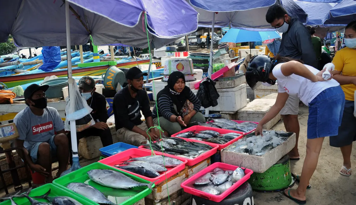 Pedagang ikan menjual hasil tangkapan di pasar tepi pantai saat Pemberlakuan Pembatasan Kegiatan Masyarakat (PPKM) Level 3 di Kedonganan, Kuta, Badung, Bali, Jumat (23/7/2021). Bali yang menyangga ekonomi masyarakatnya dari priwisata kini kelimpungan. (SONY TUMBELAKA/AFP)