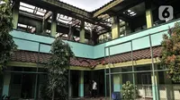 Petugas keamanan melintasi ruangan kelas usai kebakaran melanda SMA Negeri 100 Jakarta, Rabu (1/7/2020). Beruntung tidak ada korban jiwa dalam kebakaran ini, namun sedikitnya tujuh ruangan beserta isinya ludes dilalap si jago merah. (merdeka.com/Iqbal S Nugroho)