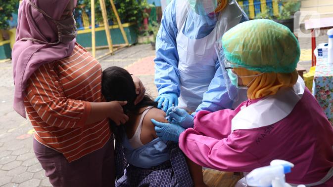 Petugas kesehatan menyuntikkan imunisasi kepaad siswa Sekolah Dasar di SDN Tangerang 1, Kota Tangerang, Kamis (19/11/2020). Pemberian imunisasi untuk memberikan perlindungan kepada anak-anak usia SD serta meningkat daya tahan tubuh serta mencegah berbagai penyakit. (Liputan6.com/Angga Yuniar)
