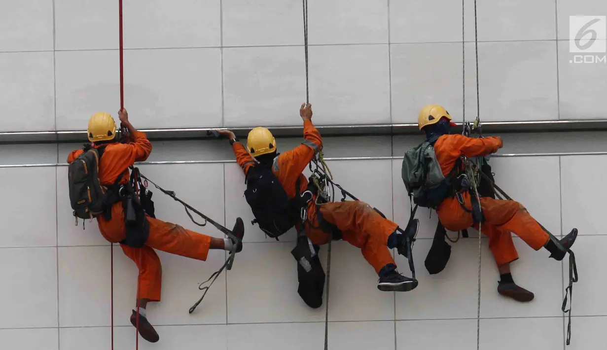 Pemandangan ketika pekerja membersihkan salah satu gedung bertingkat di Bundaran Hotel Indonesia, Jakarta, Rabu (14/3). BPJS Ketenagakerjaan mencatat 123 ribu kasus kecelakaan kerja tercatat sepanjang 2017. (Liputan6.com/Angga Yuniar)