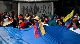 Venezuela mengklaim bahwa 55 personel militernya tewas dalam serangan militer Amerika Serikat tersebut. Tampak dalam foto, orang-orang menghadiri unjuk rasa dukungan untuk mantan Presiden Venezuela Nicolas Maduro dan istrinya Cilia Flores di Caracas pada 6 Januari 2026. (Federico PARRA/AFP)