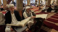 Sejumlah pria membaca Al-Quran selama bulan Ramadan di Masjid Agung Sanaa, Yaman, Minggu (26/4/2020). Kaligrafi dan dekorasi merupakan kekhasan Masjid Agung Sanaa. (Mohammed HUWAIS/AFP)