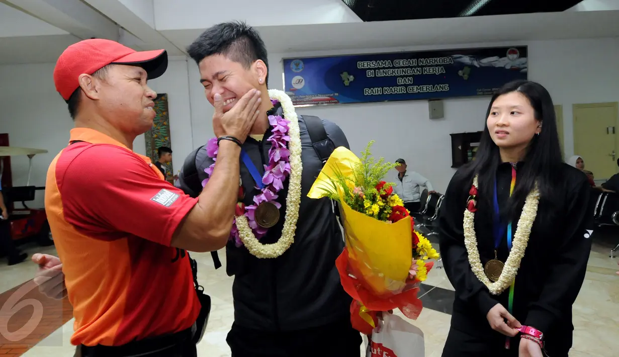 Pelatih kepala nomor ganda campuran pelatnas PBSI, Richard Mainaky (kiri) menyambut kedatangan Praveen Jordan/Debby Susanto di Bandara Soetta, Banten, Rabu (16/3/2016). Praveen/Debby menjadi juara All England 2016. (Liputan6.com/Helmi Fithriansyah)