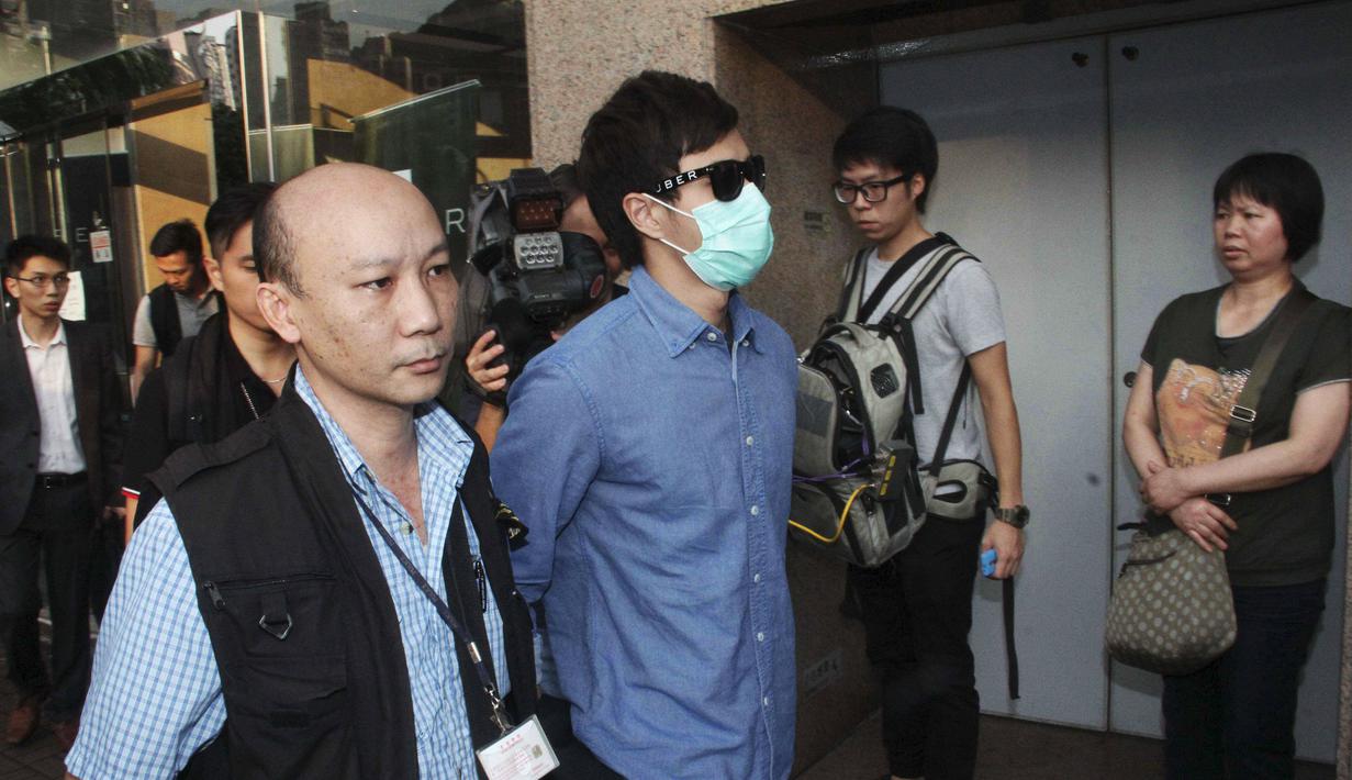 Polisi Hong Kong mengamankan seorang staff saat razia di kantor Uber Inc, Selasa (11/8/2015). Dalam razia ini polisi mengamankan 5 orang yang tertangkap basah memberikan jasa pelayanan sebagai sopir taxi dengan kendaraan ilegal. (REUTERS/Apple Daily)