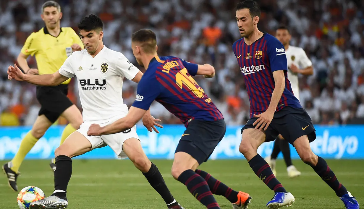 Gelandang Valencia, Carlos Soler, berusaha melewati bek Barcelona, Clement Lenglet, pada laga Copa del Rey di Stadion Benito Villamarin, Sevilla, Sabtu (25/5). Barcelona kalah 1-2 dari Valencia. (AFP/Jose Jordan)