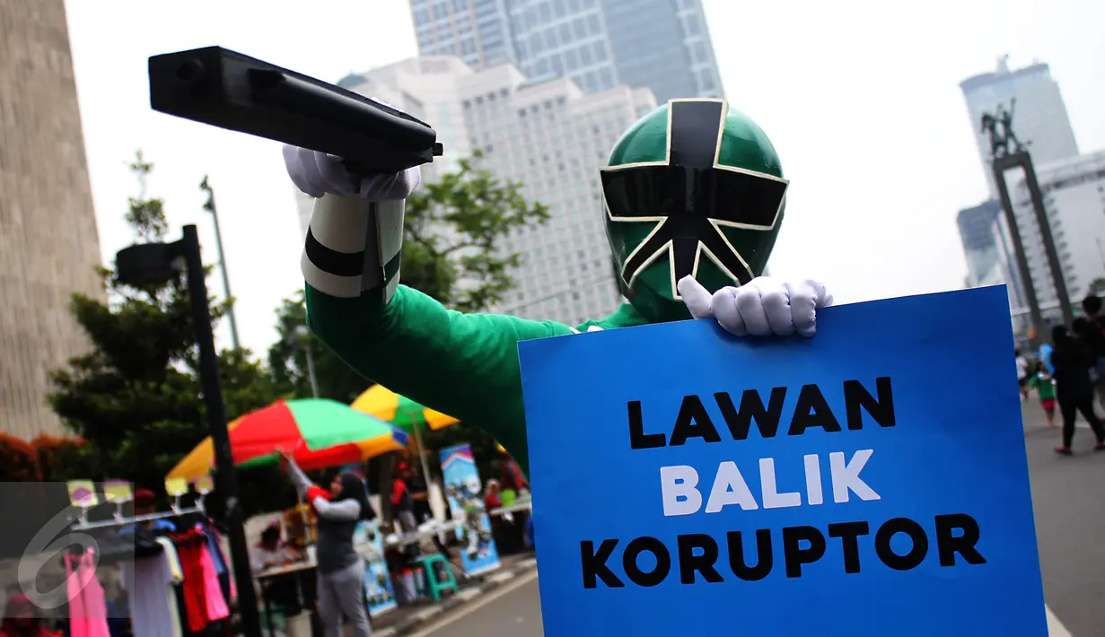 Seperhero membawa poster saat melakukan aksi teaterikal di Bundaran HI, Jakarta, Minggu (16/4). Dalam aksi teaterikal tersebut para superhero menyuarakan untuk terus mendukung KPK. (Liputan6.com/Angga Yuniar)