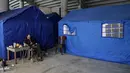 Saat ini, stadion yang sempat terbengkalai akibat kurang perawatan beralih fungsi menjadi tempat penampungan darurat bagi warga untuk menghindari serangan udara Israel. Tampak dalam foto, seorang pengungsi menghisap shisha di samping tenda-tenda yang didirikan di dalam Camille Chamoun Sports City Stadium, yang telah diubah menjadi tempat penampungan bagi orang-orang yang melarikan diri dari serangan udara Israel di Lebanon selatan, Beirut, Lebanon, Rabu 8 April 2026. (AP Photo/Bilal Hussein)