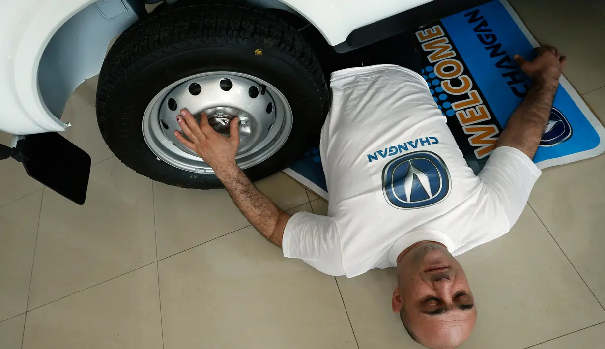 Norik Yajian beristirahat usai tubuhnya dilindas sebuah mobil pada sebuah atraksi di Tbilisi, Georgia, Selasa (16/2). Atraksi ini nekat dilakukan Norik untuk memecahkan rekor Guinness. (REUTERS/David Mdzinarishvili)