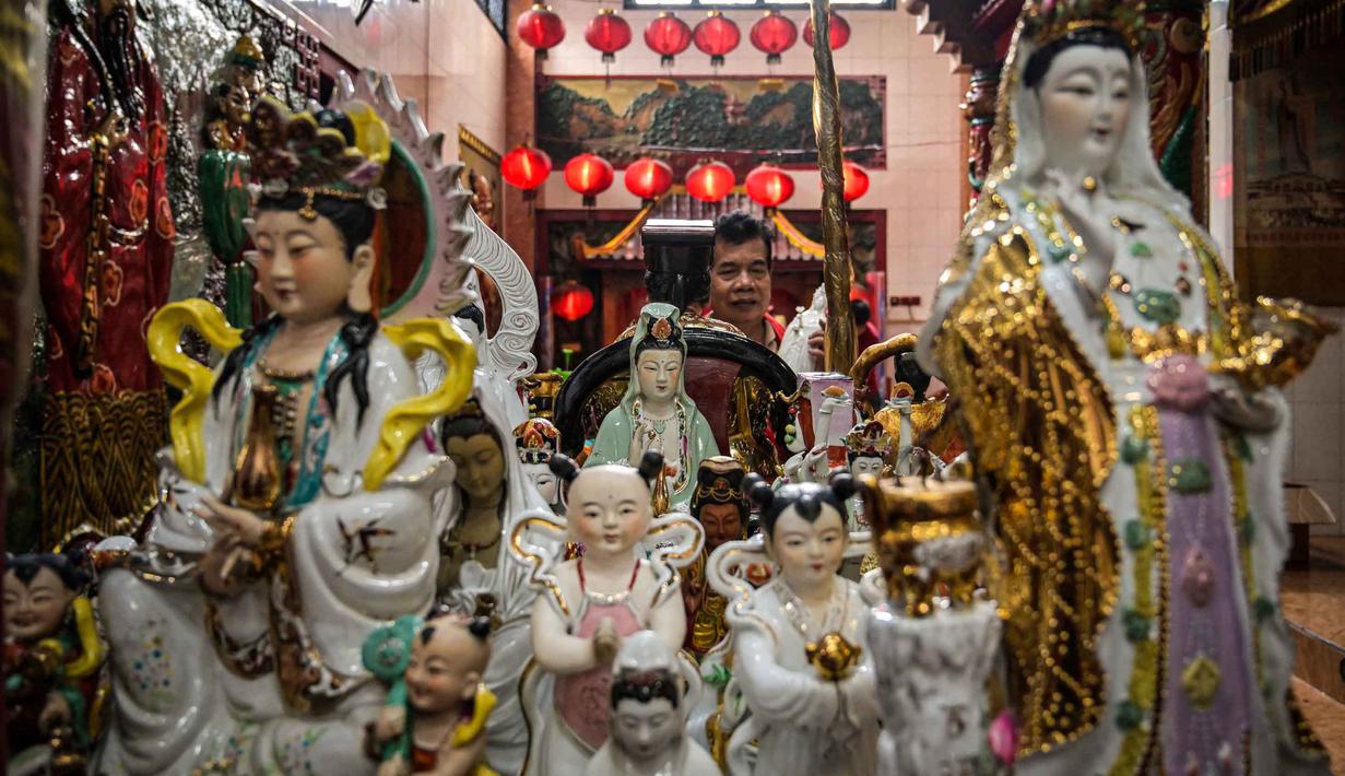 Para sukarelawan membersihkan patung-patung dewa di Kuil Hong San Ko Tee, Surabaya, Jawa Timur, pada Rabu 11 Februari 2026. (JUNI KRISWANTO/AFP)