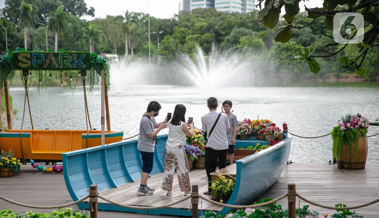 Wisatawan berfoto saat mengunjungi Senayan Park, Jakarta, Rabu (9/12/2020). Libur Nasional Pilkada Serentak 2020 dimanfaatkan sebagian warga Jakarta dan sekitarnya untuk mengunjungi tempat rekreasi bersama keluarga. (Liputan6.com/Faizal Fanani)