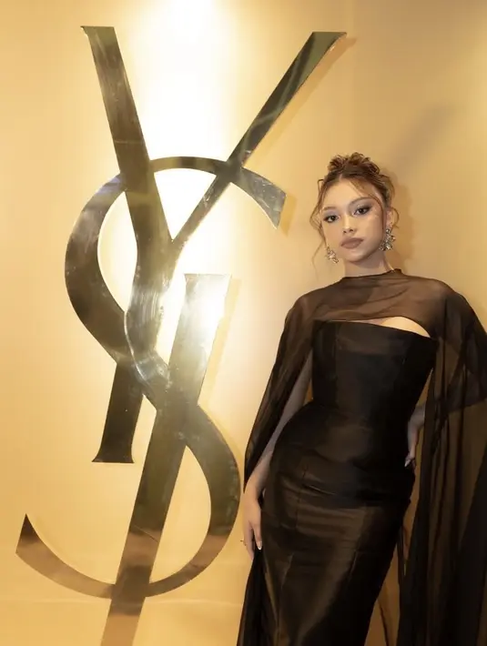 Naura Ayu tampil elegan dengan long dress satin polos model tube. Dipadukan atasan sheer yang menjuntai ke bawah. Ia tampak mengenakan anting-anting silver besar. [@naura.ayu]