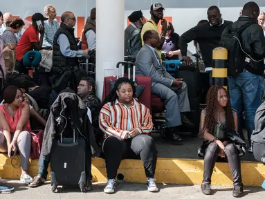Penumpang tidak dapat memasuki terminal keberangkatan Kenya Airways setelah pemogokan pekerja maskapai di Bandara Internasional Jomo Kenyatta, Nairobi, Rabu (6/3). Aksi itu menyebabkan ratusan penumpang terlantar di bandara. (Yasuyoshi CHIBA/AFP)