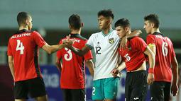 Narendra kemudian membantu Zhogayyer untuk berdiri lantas merangkulnya sambil bersalaman dengan pemain Timnas Palestina U-17 lainnya yakni Ibrahim Alfuqaha (kiri). (Bola.com/M Iqbal Ichsan)