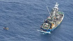 Kapal nelayan menyelamatkan perahu pengangkut tujuh penumpang selamat kapal feri MV Butiraoi yang hilang di perairan Pasifik di Kiribati, Minggu (28/1). Mereka berhasil bertahan hidup tanpa air maupun peralatan komunikasi. (New Zealand Defence Force/AP)