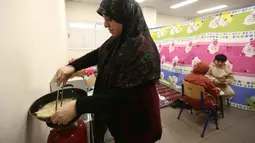 Lebih dari setengah juta warga terpaksa mengungsi setelah serangan Israel menghantam beberapa wilayah di Lebanon. Tampak dalam foto, seorang perempuan pengungsi yang tinggal bersama keluarganya di ruang kelas sekolah, setelah melarikan diri dari serangan udara Israel di pinggiran selatan Beirut, Lebanon, duduk untuk berbuka puasa bersama, pada 7 Maret 2026. (Ibrahim AMRO/AFP)