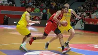 Power forward Timnas Basket Indonesia, Derrick Michael Xzavierro, mendapatkan pengawalan dari pemain Australia pada laga FIBA Asia Cup 2022 yang digelar di Istora Senayan, Jakarta, Sabtu (16/7/2022). (Bola.com/Bagaskara Lazuardi)
