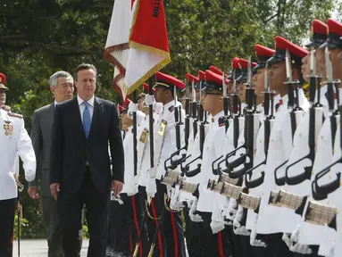 PM Inggris David Cameron  ditemani PM ketiga Singapura Lee Hsien Loong menginspeksi barisan tentara dalam seremonial penyambutan di Istana Kepresidenan Singapura, Rabu (29/7/2015). Inggris ingin perkuat kerja sama dengan negara ASEAN. (REUTERS/Edgar Su)