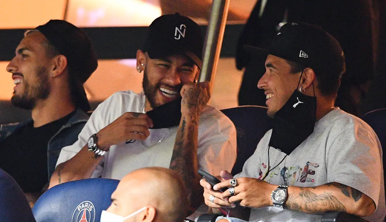 Pemain PSG, Neymar tertawa saat menyaksikan pertandingan antara PSG melawan Metz pada laga Liga Prancis di Stadion Parc des Princes, Kamis (17/9/2020). Akibat pertikaian di laga melawan Marseille, Neymar dihukum larangan dua pertandingan. (AFP/Franck Fife)