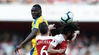 Duel udara terjadi antara Christian Benteke dan Koscielny pada laga lanjutan Premier League yang berlangsung di Stadion Emirates, Minggu (21/4). Arsenal kalah 2-3 kontra Crystal Palace. (AFP/Adrian Dennis)