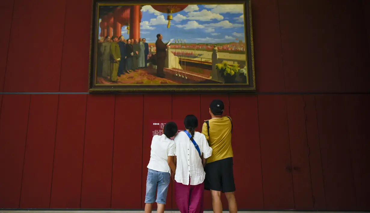 Keluarga melihat lukisan minyak di atas kanvas yang berjudul "Upacara Pendirian Tiongkok" oleh Dong Xiwen, ketika mereka mengunjungi Museum Nasional Cina di Beijing (22/8/2019). Museum ini dibangun oleh Kementerian Kebudayaan Republik Rakyat Tiongkok. (AFP Photo/Wang Zhao)