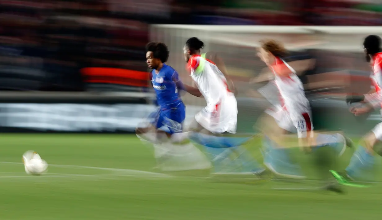 Gelandang Chelsea, Willian berlari mengejar bola dibayangi pemain Slavia Praha dalam laga leg pertama perempat final Liga Europa 2018-19 di Sinobo Stadium, Kamis (11/4). Chelsea sukses meraih kemenangan atas Slavia Praha dengan skor tipis 1-0. (AP/Petr David Josek)