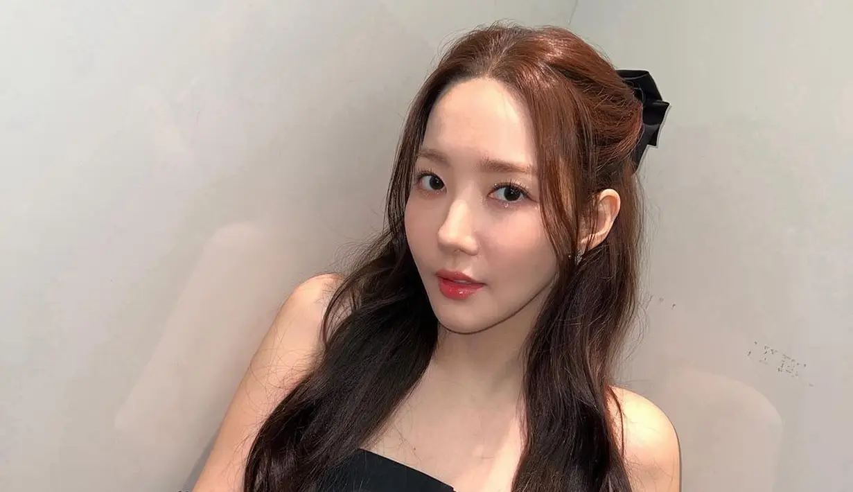 Di foto ini, Park Min Young tampil cantik mengenakan strapless top berwarna hitam, dipadu dengan celana denim. Park Min Young tampil semakin cute dengan manset lengan lace hitam. Rambutnya di hal-ponytail menggunakan jepit pita hitam. [Foto: Instagram/rachel_mypark]