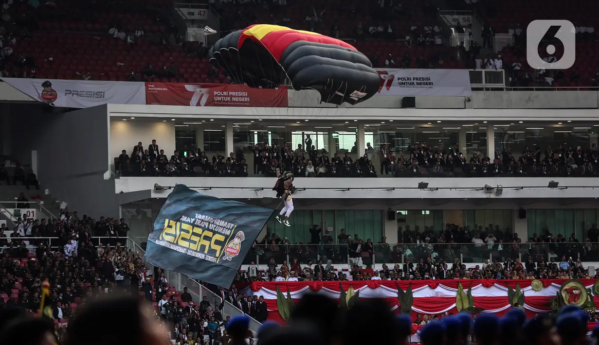 Presiden Joko Widodo atau Jokowi dan Ibu Negara Iriana kagum dengan sejumlah aksi penerjun payung dari Polri. Presiden Jokowi tersenyum ceria dan bertepuk tangan melihat aksi mereka. (Liputan6.com/Johan Tallo)