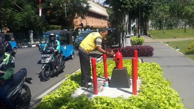Petugas mengecat hydrant di depan DPD Golkar DKI dengan warna merah