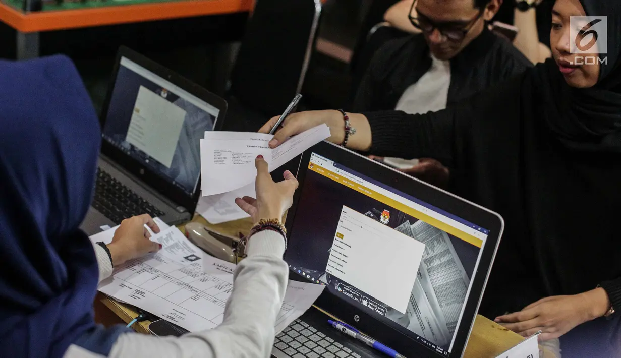Warga menyerahkan dokumen saat mengurus formulir A5 atau surat pindah memilih di Kantor KPU Kota Jakarta Pusat, Minggu (17/2). KPU menggelar pelayanan pindah memilih yang dibagi menjadi dua tahap. (Liputan6.com/Faizal Fanani)