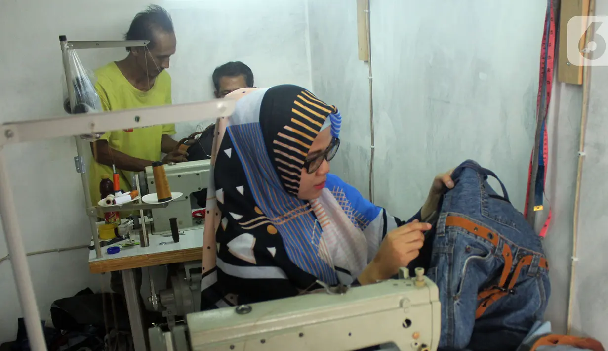 Perajin Risma Eljundi menyelesaikan pembuatan tas dari bahan celana jeans bekas di Legok, Tangerang, Banten, Senin (11/11/2019). Tas berbahan jeans itu dipasarkan ke kawasan Bandung serta pasar daring. (merdeka.com/Arie Basuki)