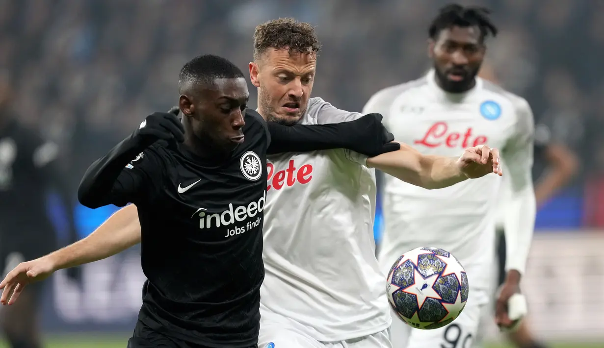 Pemain Eintracht Frankfurt Randal Kolo Muani (kiri) berduel memperebutkan bola dengan pemain Napoli Amir Rrahmani pada pertandingan sepak bola babak 16 besar Liga Champions di Deutsche Bank Arena, Frankfurt, Jerman, 21 Februari 2023. Napoli mengalahkan Eintracht Frankfurt dengan skor 2-0. (AP Photo/Michael Probst)