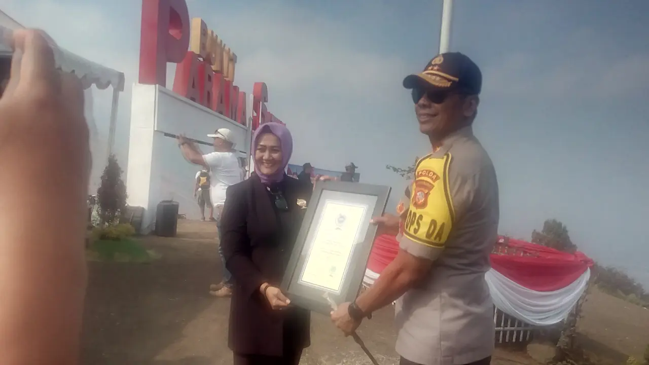Kapolda Jabar Irjen Pol. Rudy Sufahriadi, tengah menerima sertifikat penghargaan rekor dunia penerbangan Paralayang terbanyak di dunia versi RHR
