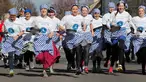 Para peserta melakukan pemanasan sebelum lomba lari dengan membawa pancake dalam lomba tahunan Pancake Trans-Atlantic, di kota Olney, Buckinghamshire, Inggris, Selasa (5/3). Peserta harus membolak-balikan pancake sambil tetap berlari. (AP/Frank Augstein)