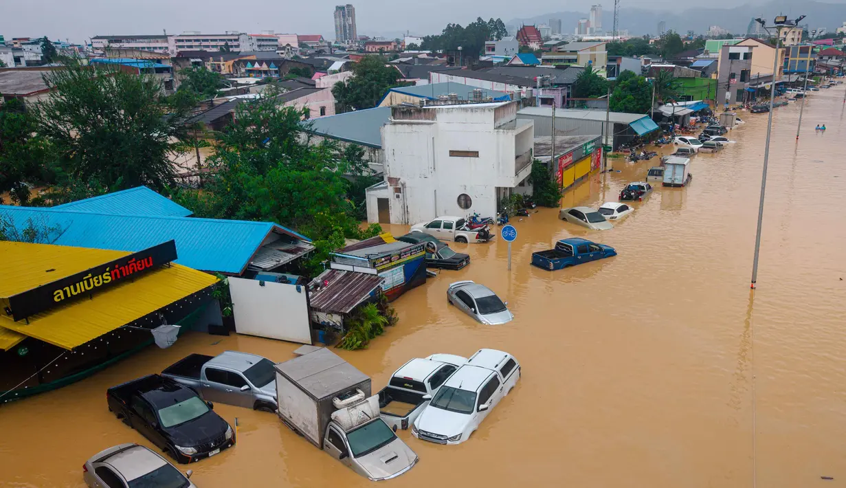 Sejumlah ahli mengatakan perubahan iklim akibat ulah manusia telah memperparah cuaca menjadi ekstrem, membuat kondisi semakin tidak terduga. Tampak foto udara yang diambil pada 26 November 2025 menunjukkan banjir yang merendam kendaraan di Hat Yai, Provinsi Songkhla, Thailand selatan. (Arnun Chonmahatrakool/THAI NEWS PIX/AFP)