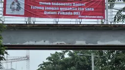 Kendaraan melintas di bawah spanduk Yusril Ihza Mahendra yang menolak penggunaan isu SARA dalam Pilkada DKI di Jalan Panjang, Jakarta, Rabu (2/11). Jelang Pilkada DKI 2017, spanduk imbauan tepis isu SARA mulai bertebaran. (Liputan6.com/Yoppy Renato)