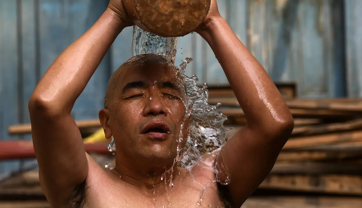 Seorang pendeta mandi suci sebelum mengambil bagian dalam prosesi membawa Seto Machindranath, dewa pelindung Nepal, selama festival kereta di Kathmandu (9/4/2022). (AFP/Prakash Mathema)