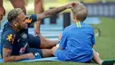 Pemain Brasil, Neymar mengusap kepala putranya, Davi Lucca di sela sesi latihan di Sochi, Rusia, Jumat (29/6). Neymar mengajak putranya saat mengikuti latihan bersama Timnas Brasil di Piala Dunia 2018. (AP Photo/Andre Penner)