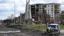 Puing-puing mobil terlihat di alun-alun pusat Borodianka, barat laut Kiev, pada 4 April 2022, di tengah invasi Rusia ke Ukraina. Saat pasukan Rusia mundur, kota kecil Borodianka, 50 km barat laut Kiev, menjadi reruntuhan. (Sergei SUPINSKY / AFP)