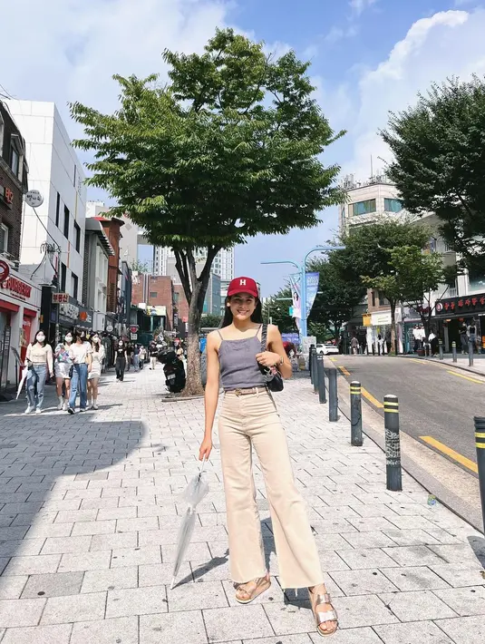 Gaya kasual Maudy Ayunda ketika pulang ke kampung halaman suaminya, Jesse Choi. Ia tampil chic mengenakan tank top abu-abu, dipadukan dengan celana panjang berwarna cokelat muda, dan topi merah. [Foto: Instagram/maudyayunda]