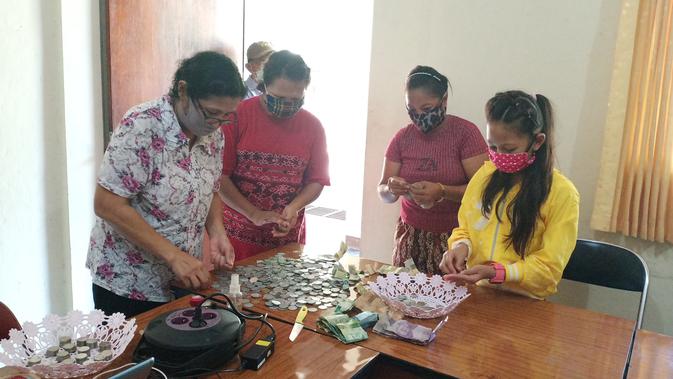 Kanayah bersama tim caritas maumere sedang menghitung uang tabungan nya disumbangkan untuk membeli APD. (Foto: Liputan6.com/Dionisius Wilibardus)
